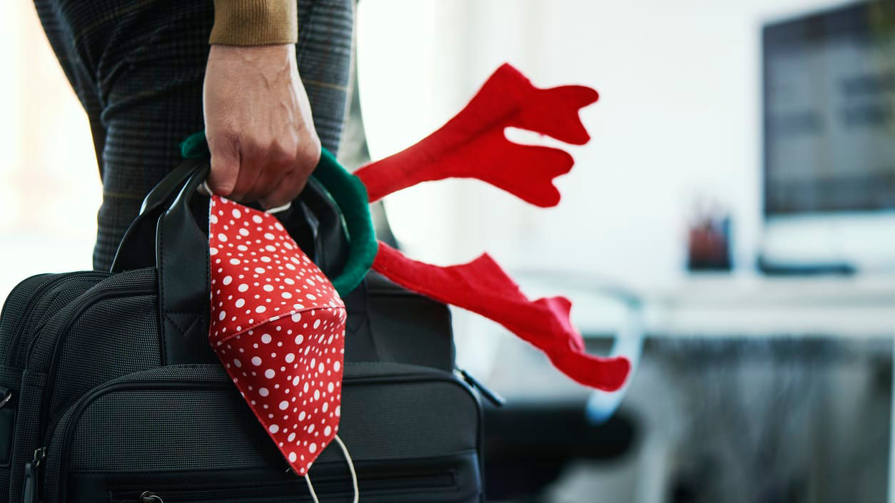 A person holding a suitcase with reindeer antlers on it.