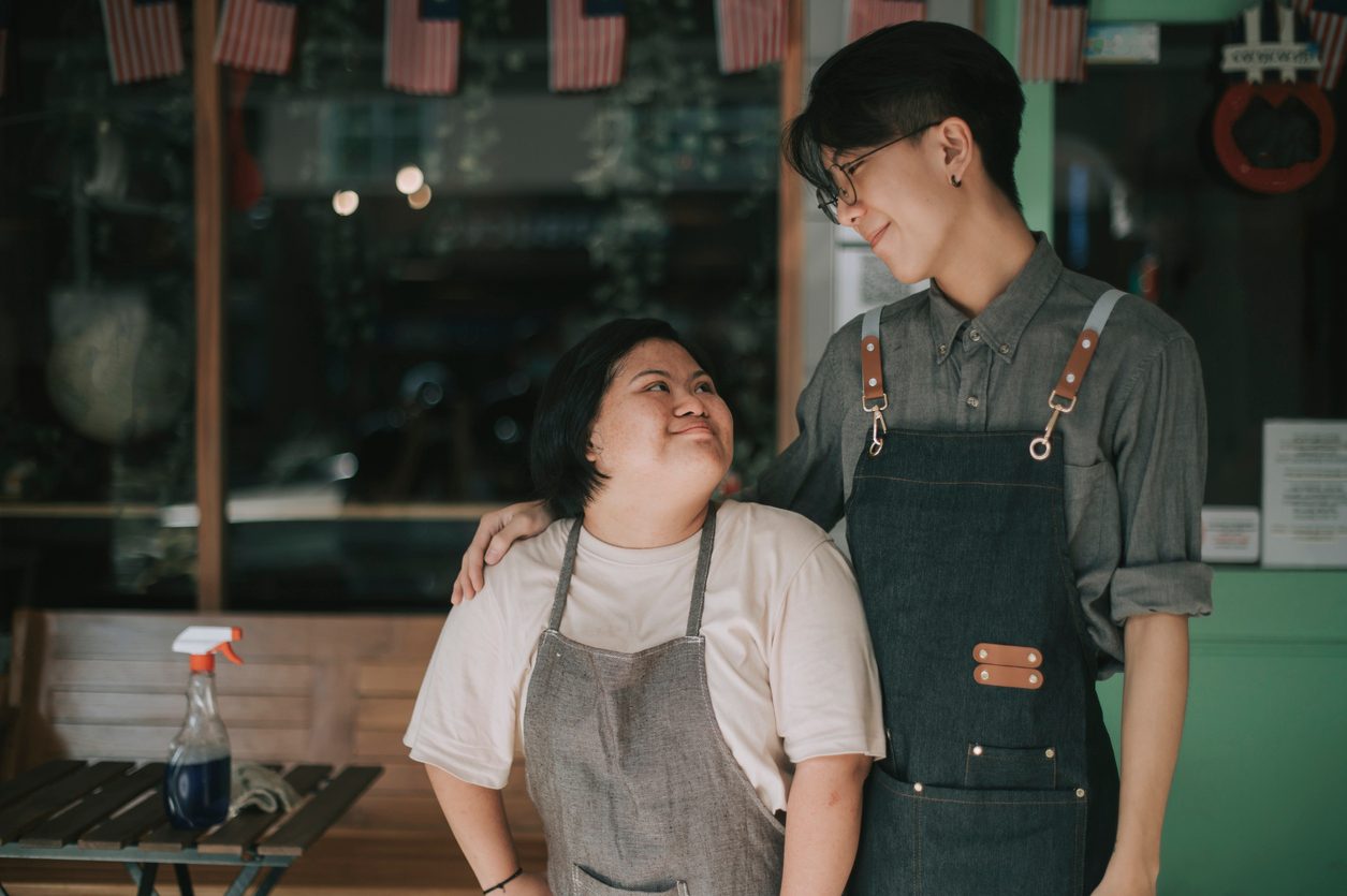 Worker with autism smiles at taller employee