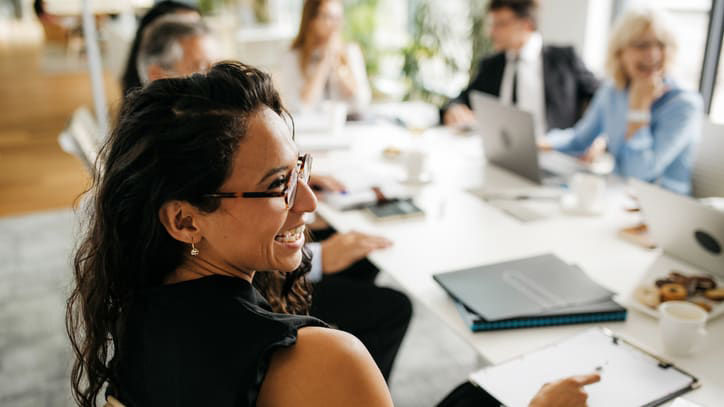 A group of business people sitting around a table in a meeting.