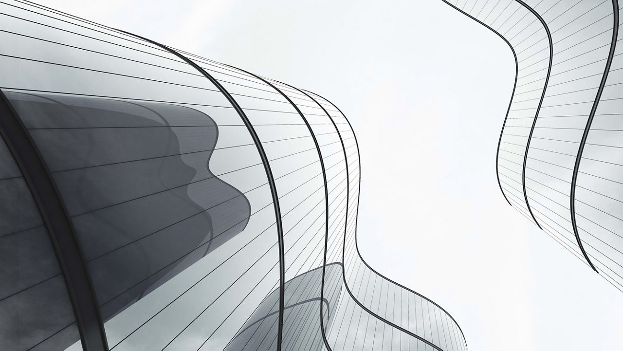 A black and white photo of a building with curved glass.