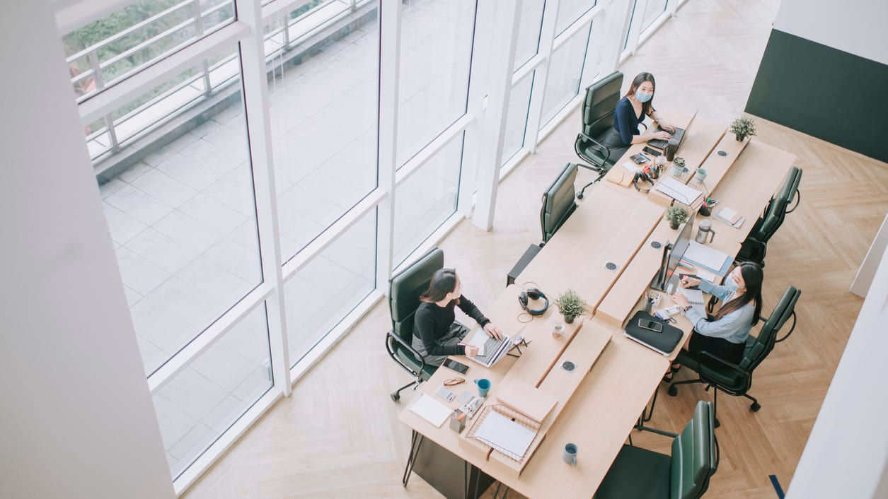 A group of people working at a desk in an office.