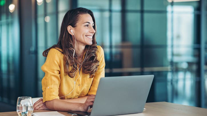 A woman sitting at a desk with a laptop in front of her.