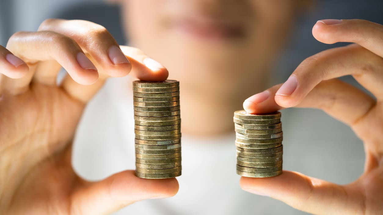 A man holding two stacks of coins in his hands.
