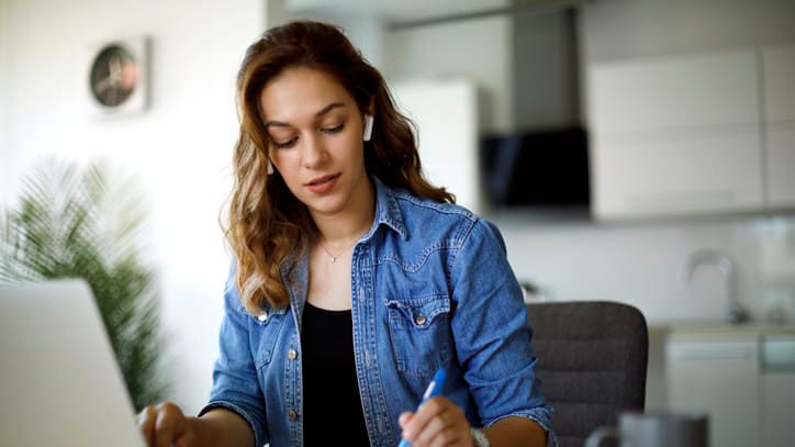 A woman working on her laptop at home.