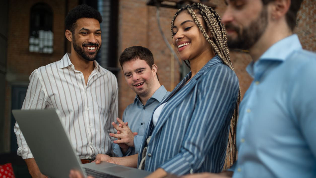 A group of business people looking at a laptop.