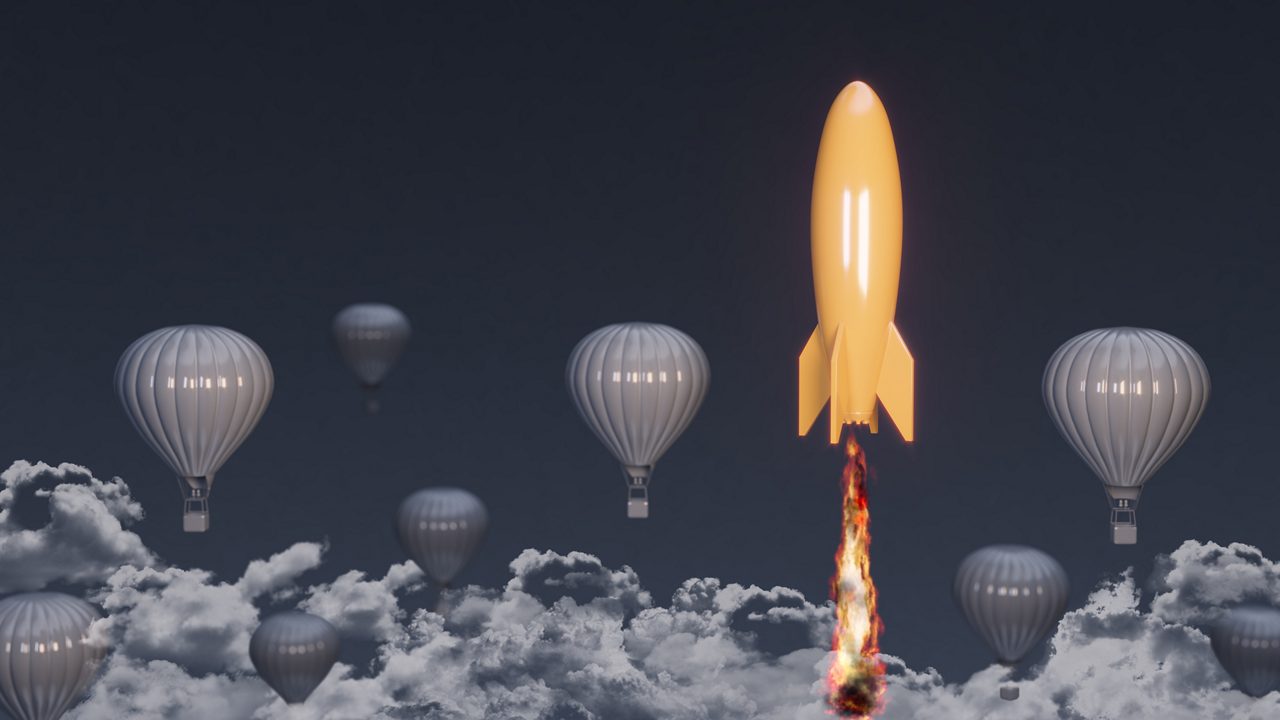 A rocket is flying in the sky with hot air balloons.