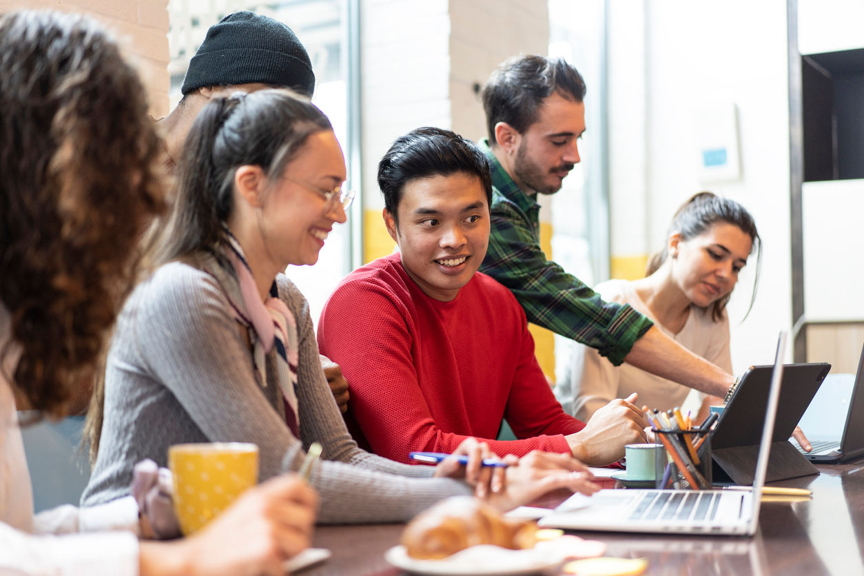 Young co-workers multiethnic team planning a new startup - Happy people working on a new project in creative coworking office - Marketing concept - Bright filter with focus on asian man face