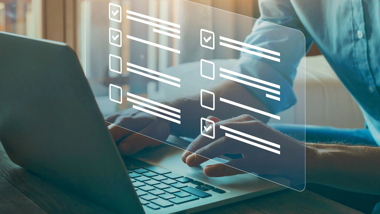 A man working on a laptop with a checklist on it.