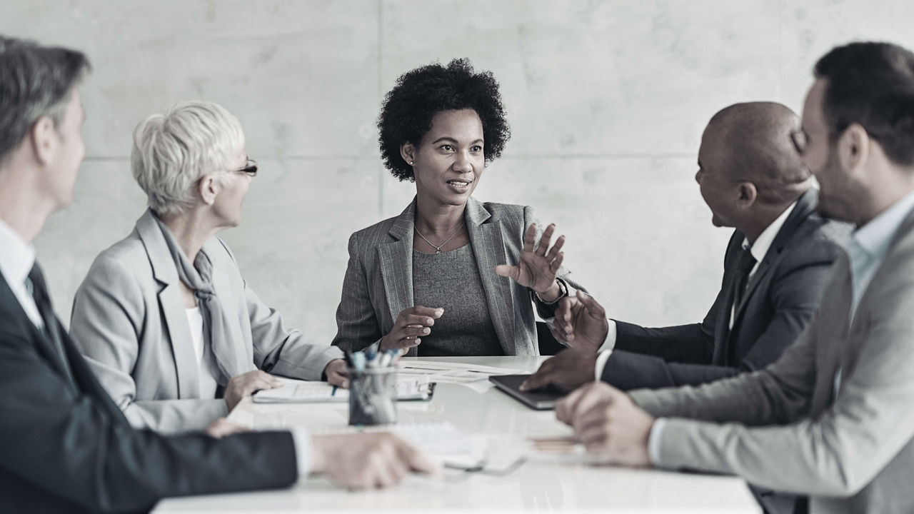 A group of business people sitting around a table.