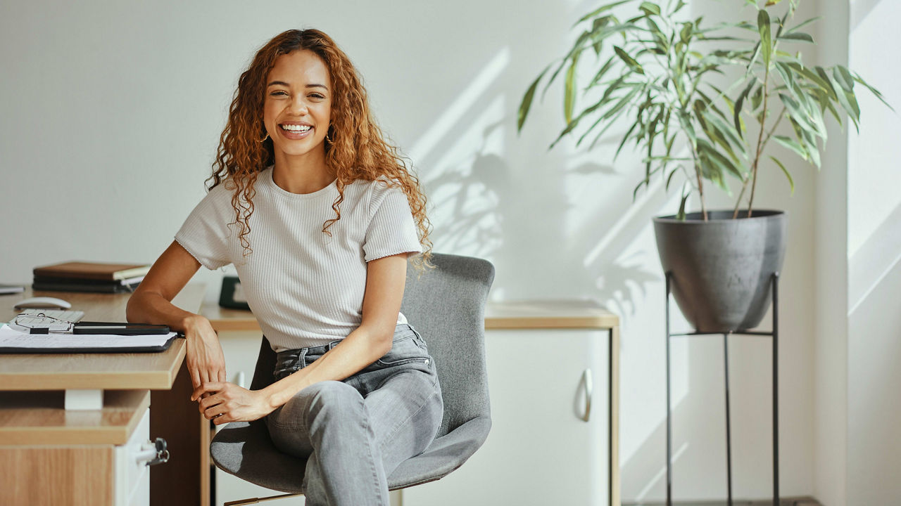 A young woman sitting at a desk in an office.