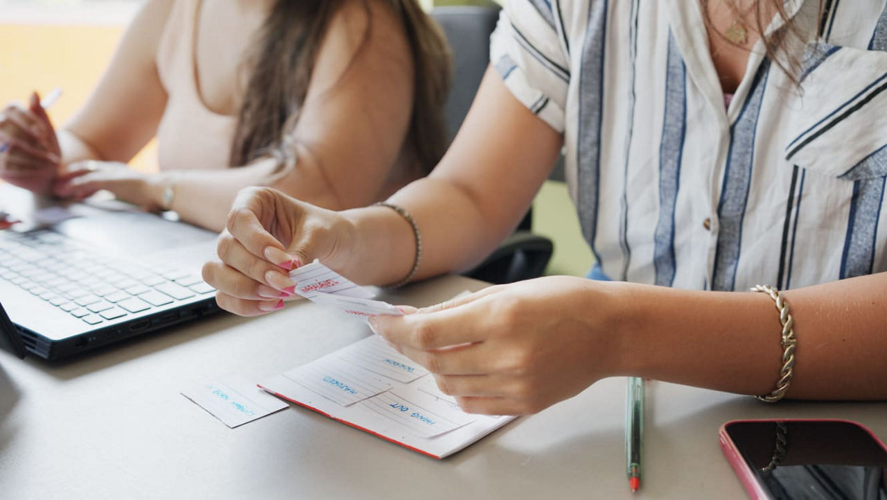 Two women working at a desk with a laptop.