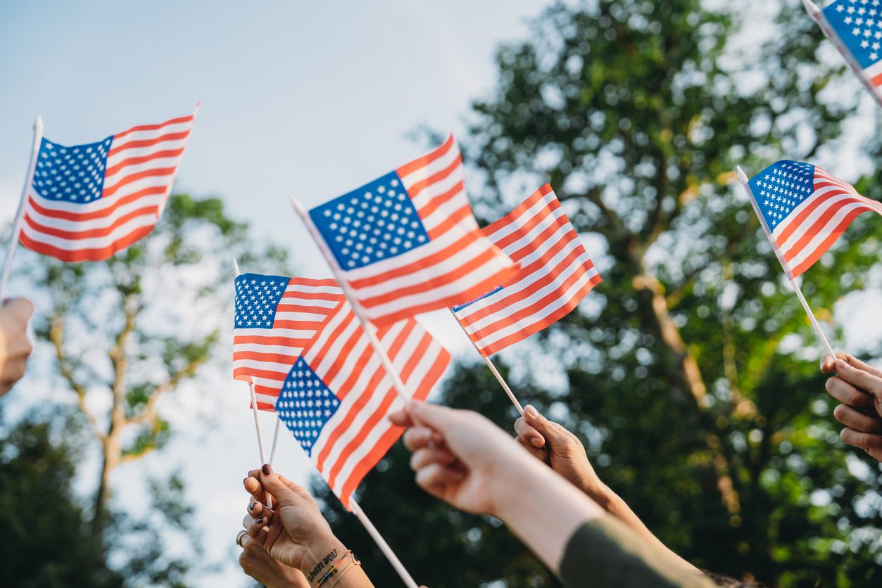 crowd hoisting American flags