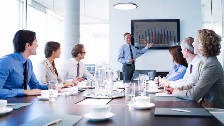 A group of business people sitting around a table in a conference room.