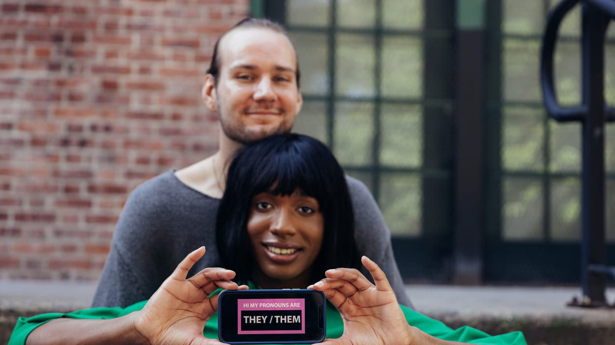 A man and woman holding up a cell phone with the word 'love' on it.