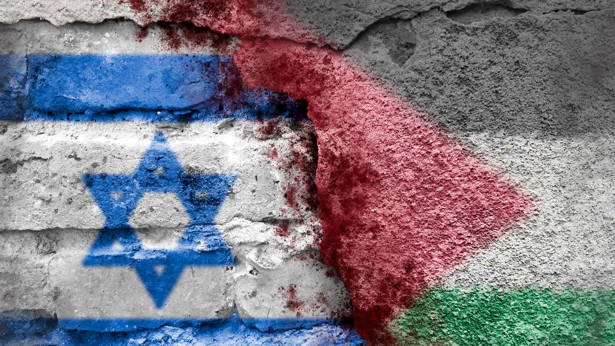 Israeli and palestinian flags painted on a brick wall.