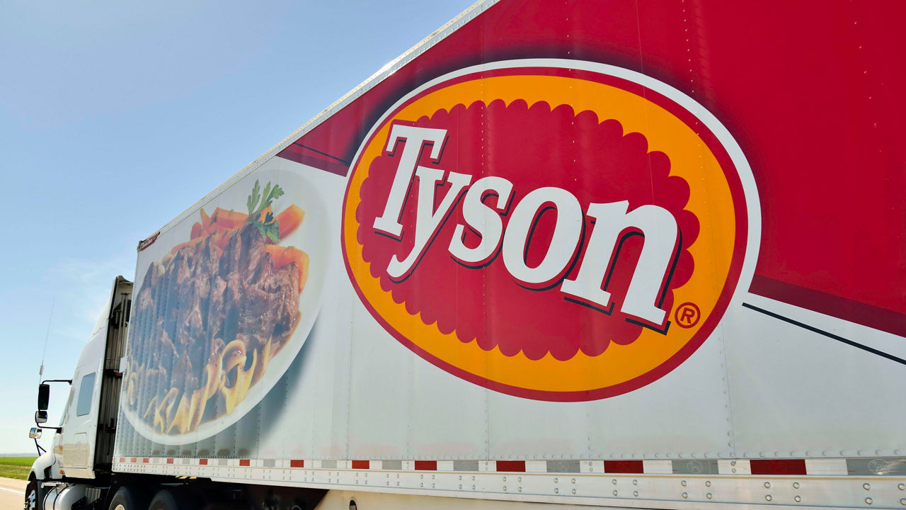 A tyson food truck is parked on the side of the road.