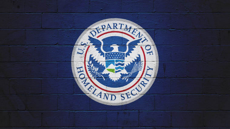 The u s department of homeland security logo on a brick wall.