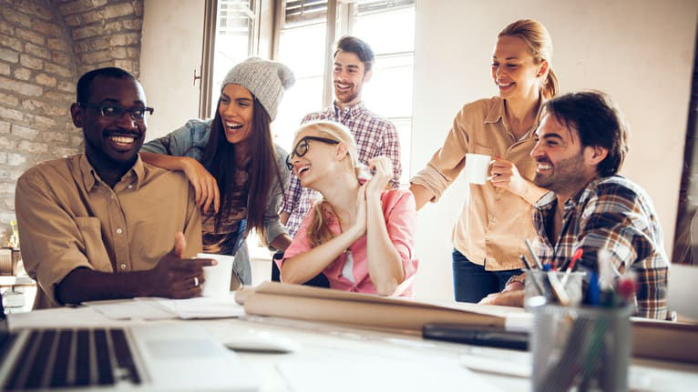 A group of people sitting around a table in an office.