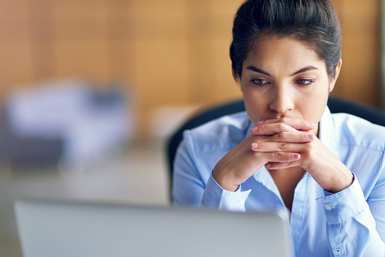 woman stressed while looking at computer screen