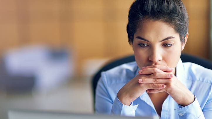 A woman is looking at her computer screen.