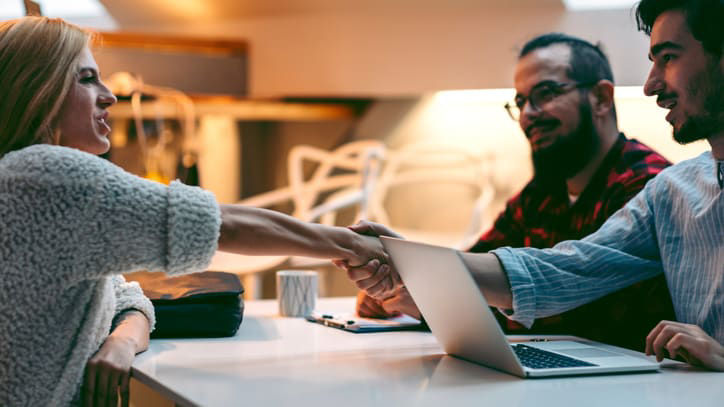 A group of people shaking hands at a table.