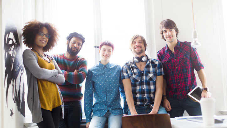 A group of people standing in front of a wall.