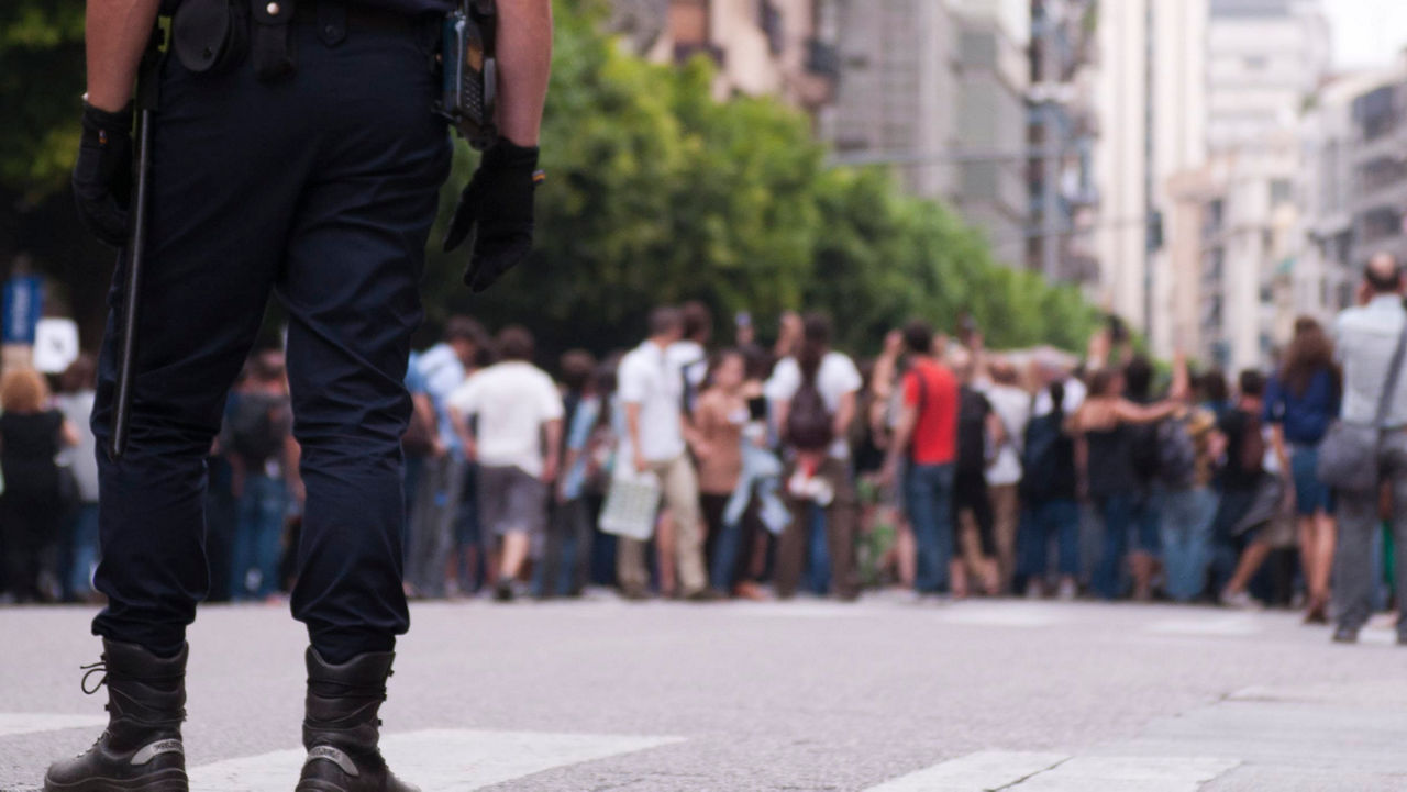 Two police officers standing in front of a crowd of people.
