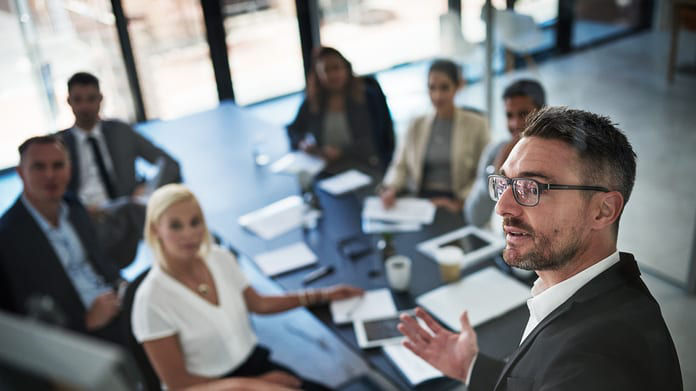 A businessman giving a presentation to a group of people.