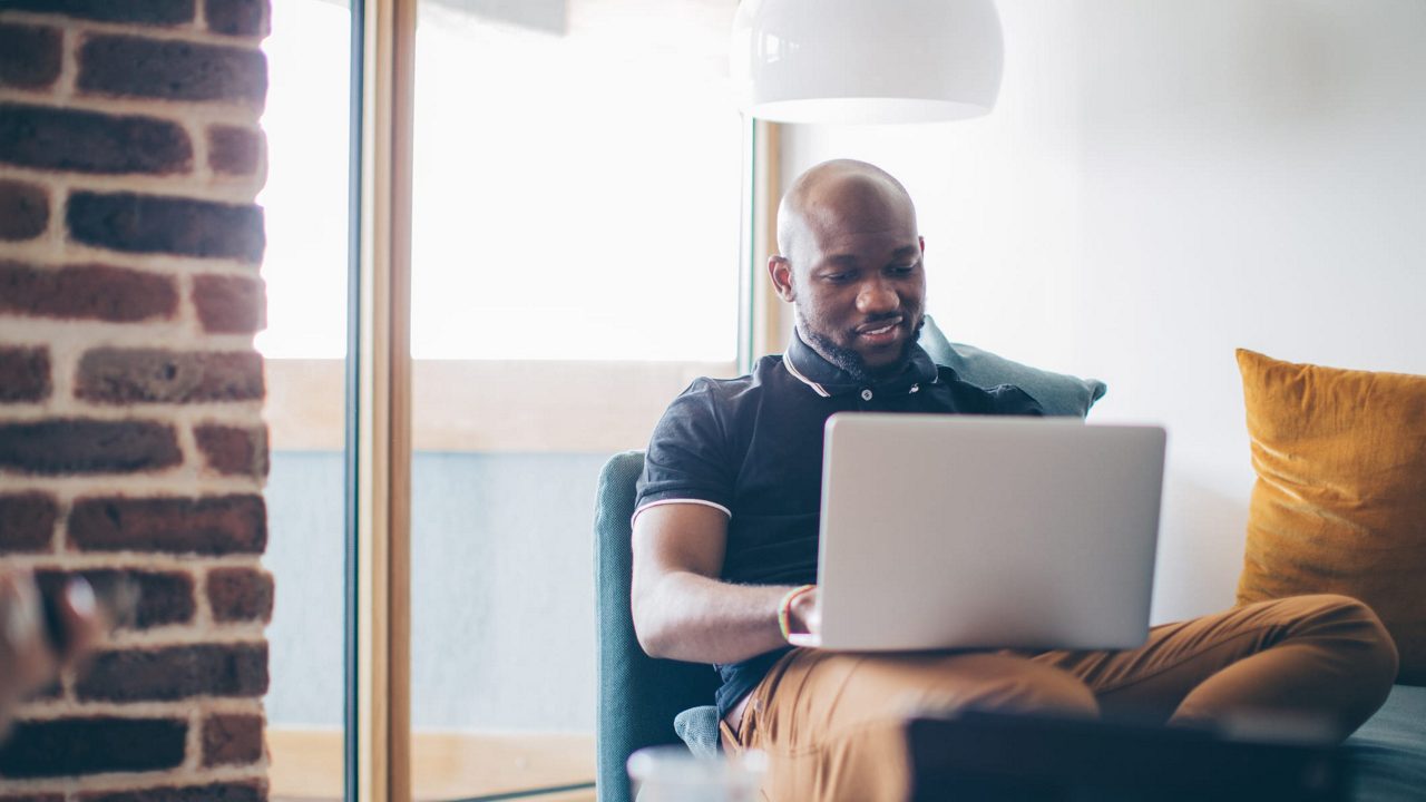 A man using a laptop in his living room.