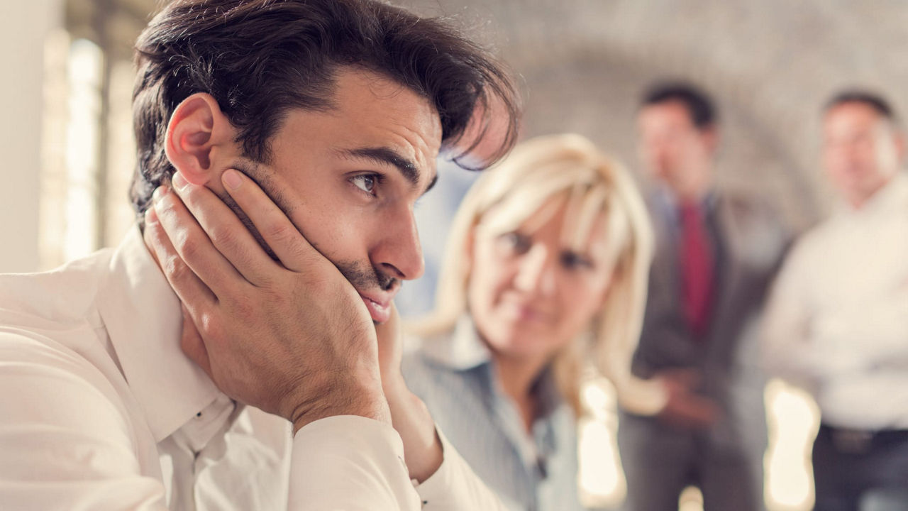 A man is sitting in front of a group of people.