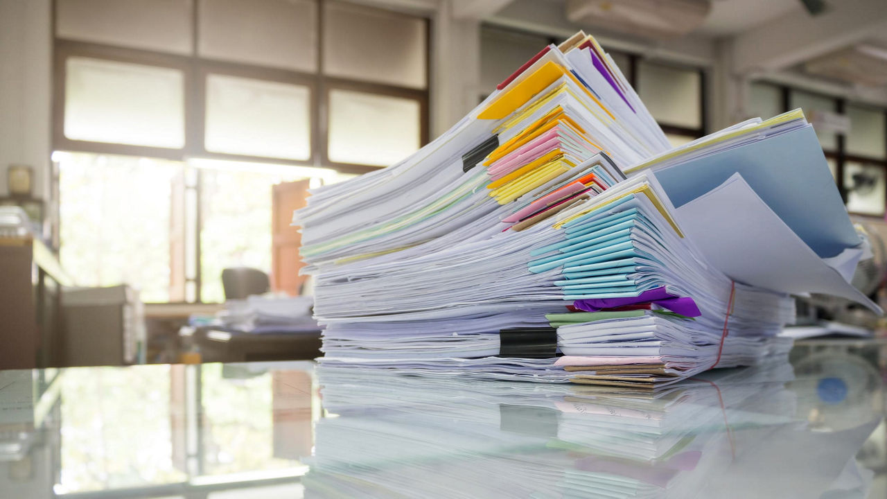 A stack of papers on a table in an office.