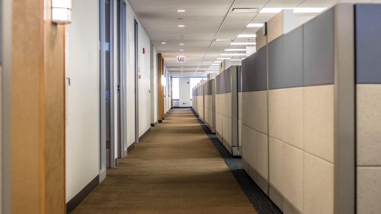 A long hallway in an office with cubicles.