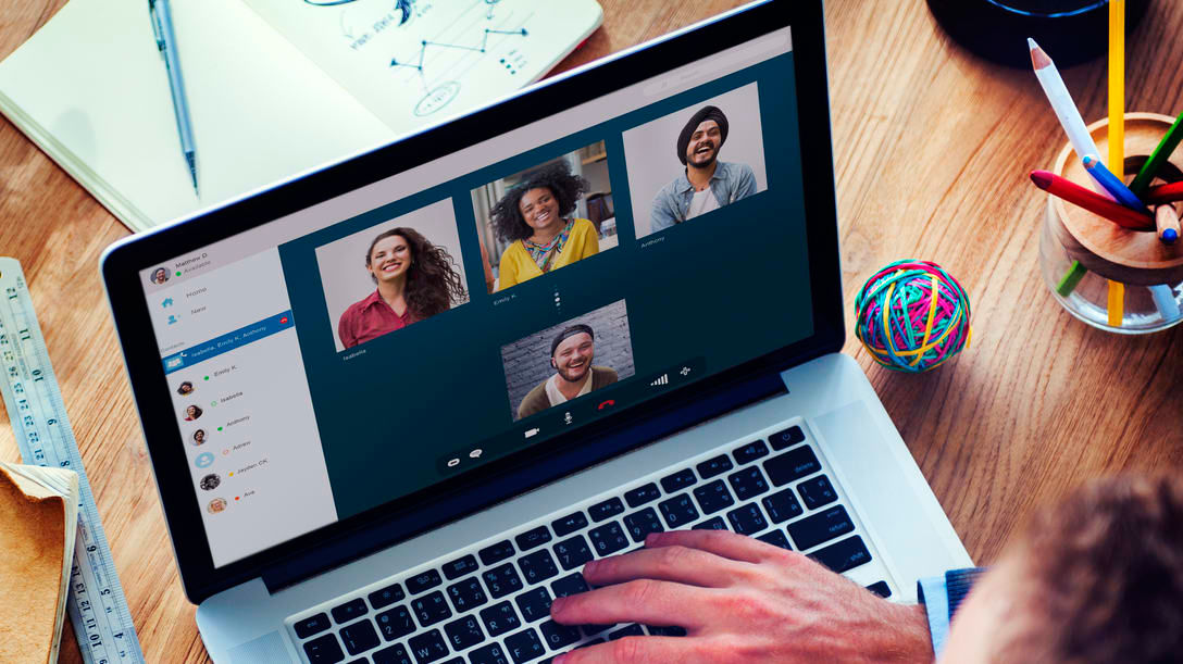 A man is using a laptop with a group of people on it.