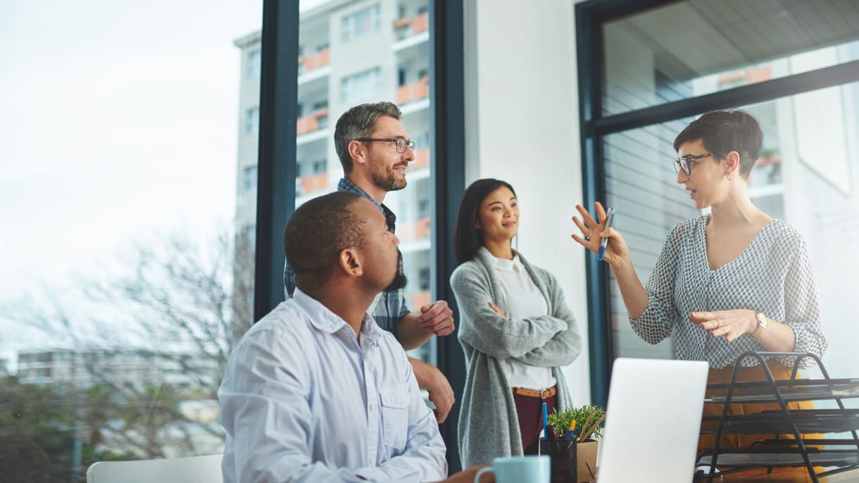 A group of people sitting around a table in an office.