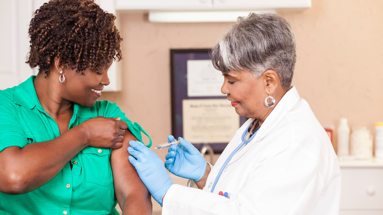 A woman is getting a vaccine from a doctor.