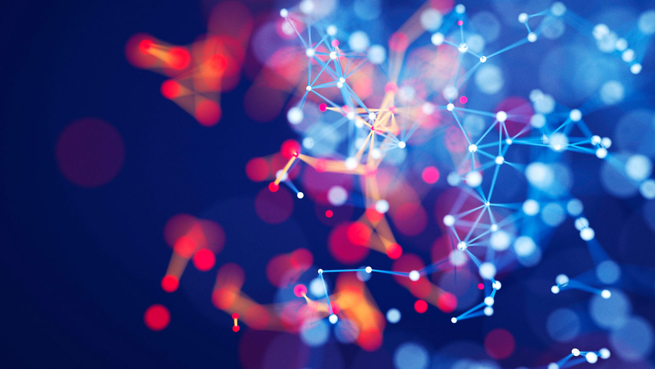 A blurry image of a network of dots on a dark background.