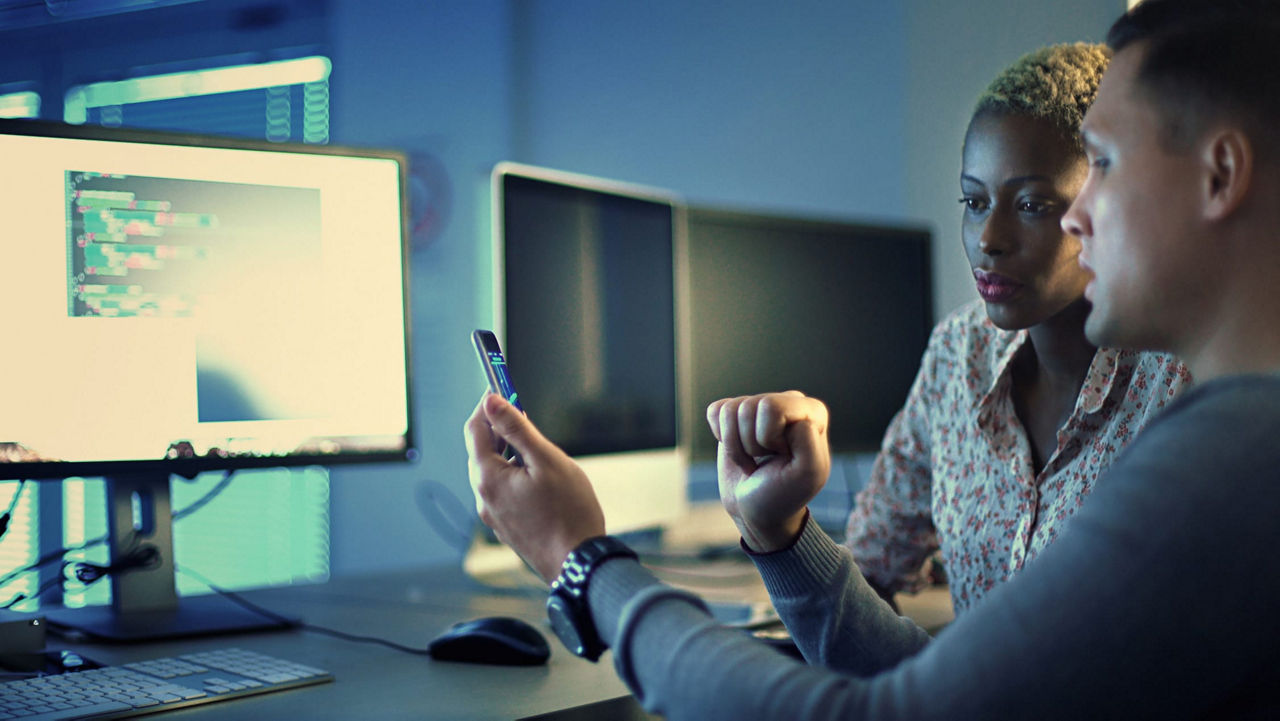 Two people looking at a computer screen.