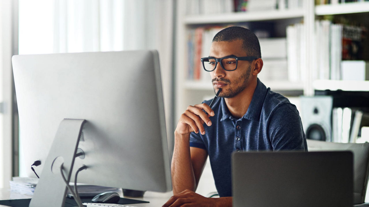 A man sitting in front of a computer screen.