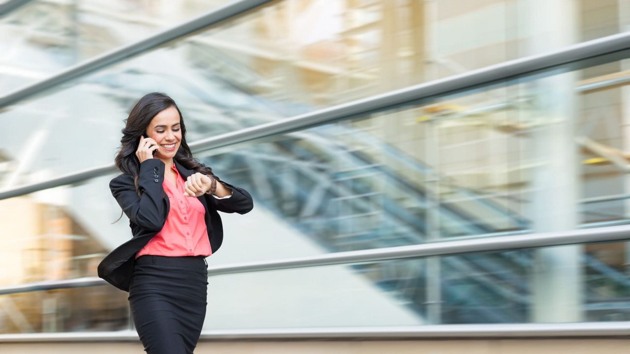 A woman in a business suit is talking on her cell phone.