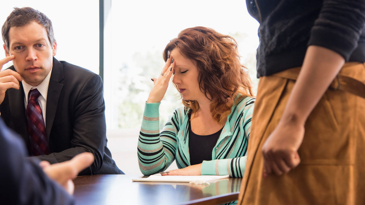 A group of people sitting around a table in a meeting.