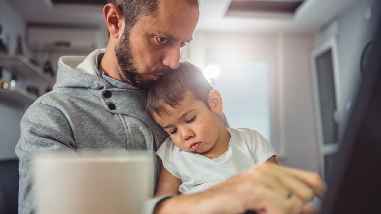 A man with a child using a laptop.