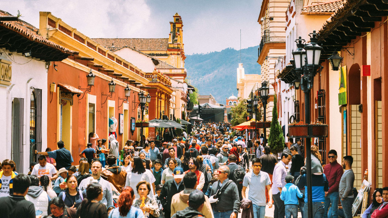 A crowded street with many people walking down it.