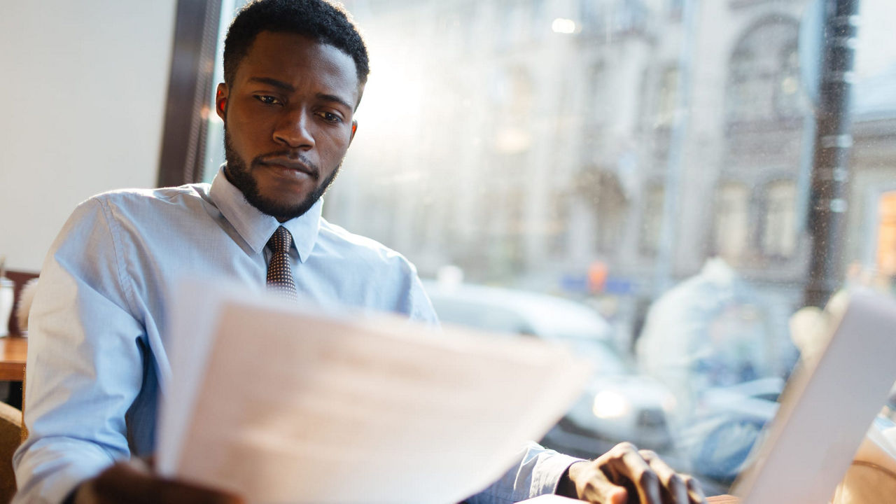 A man sitting at a table with papers in front of him.