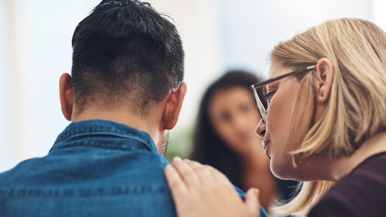 A woman is hugging a man in an office.