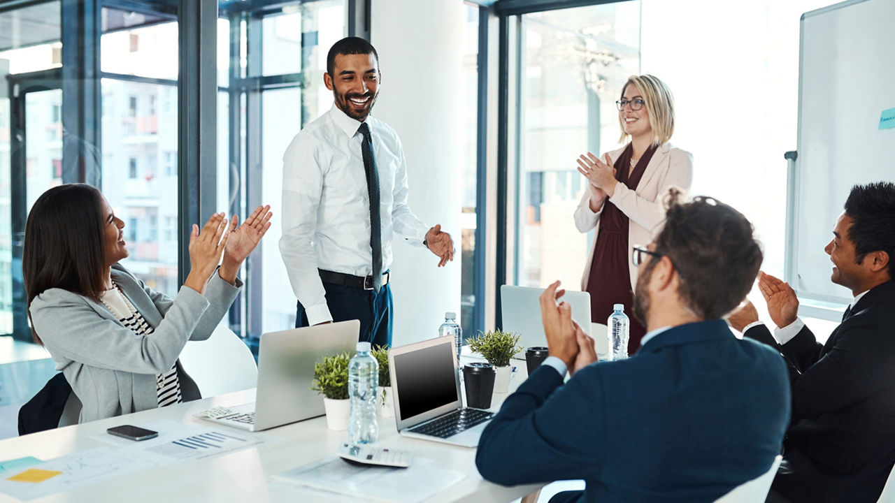 Shot of businesspeople applauding a colleague in an office