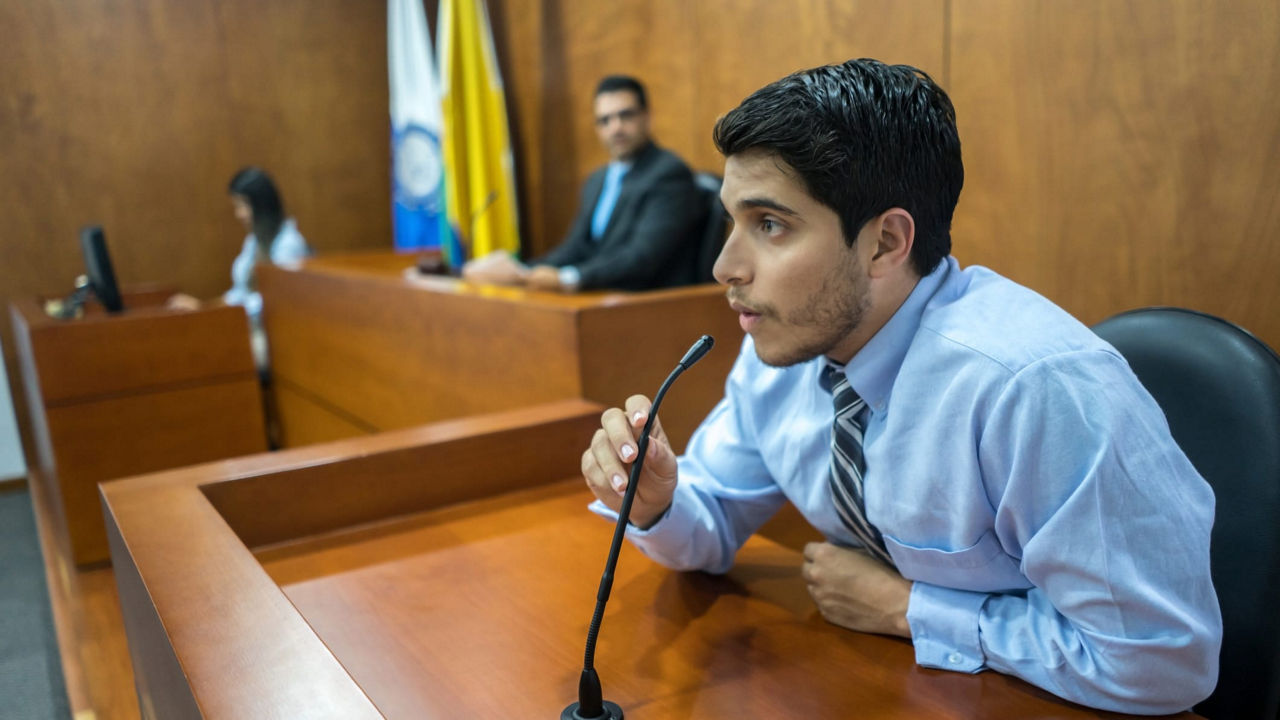 A man sitting at a desk in a courtroom.