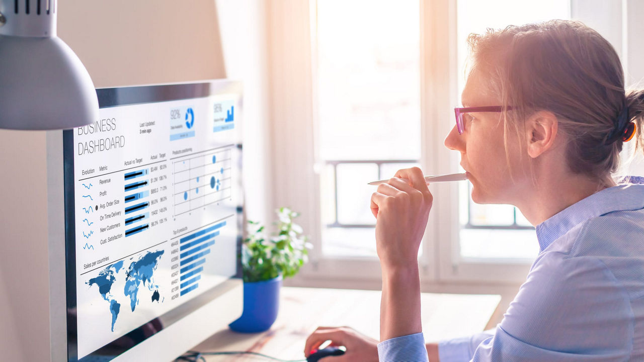 A woman looking at a graph on a computer screen.