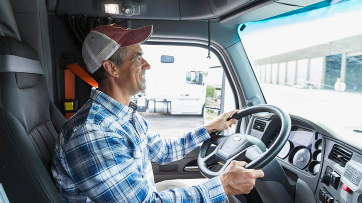 A man sitting in the driver's seat of a truck.