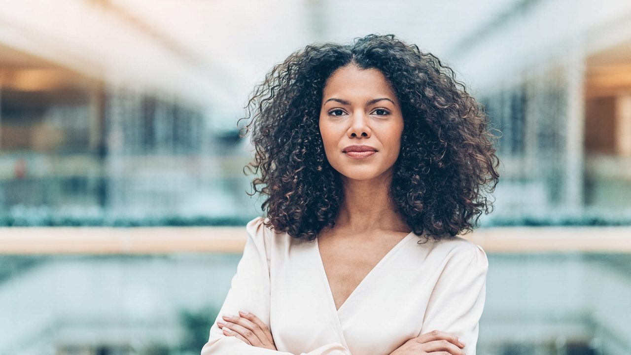 A young african american woman standing with her arms crossed.