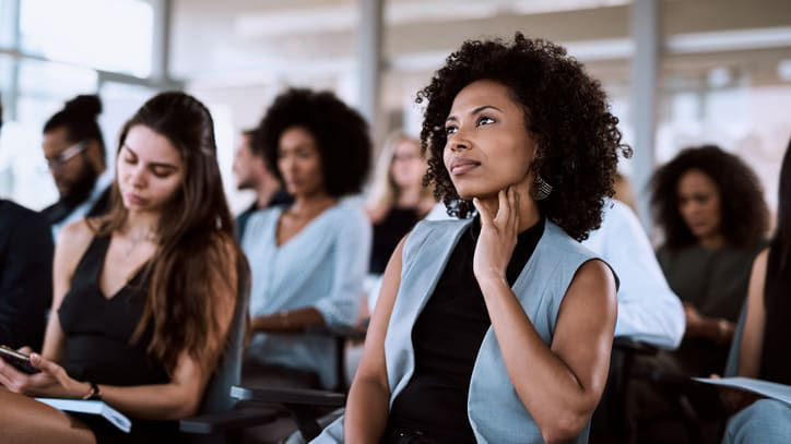 A group of people sitting in a conference room.